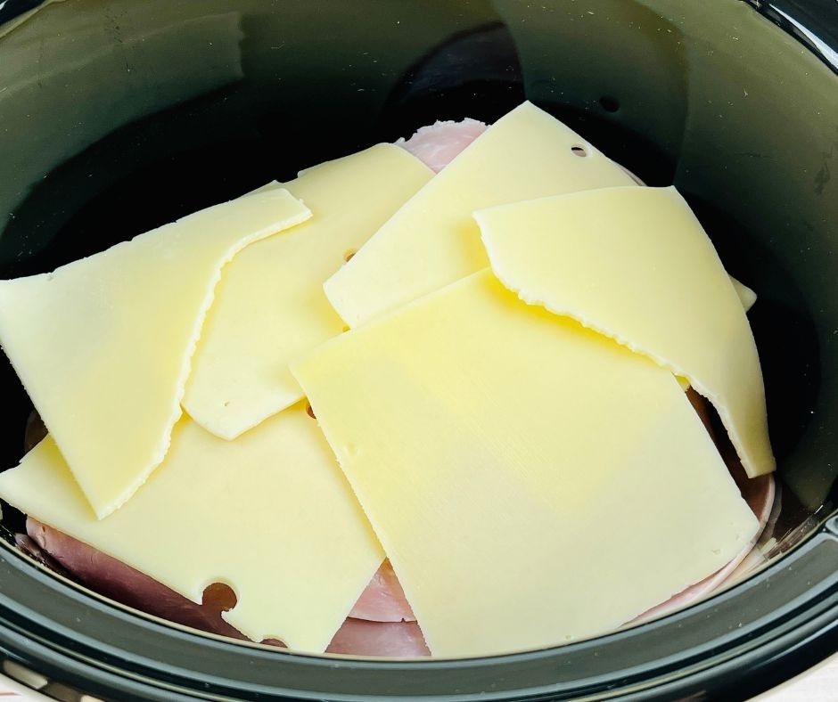 swiss cheese over the ham slices and chicken in the slow cooker